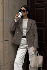 a lady wears a camel wool blazer with white pants